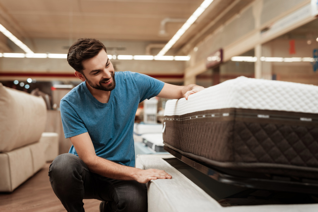 a man inspecting a bed