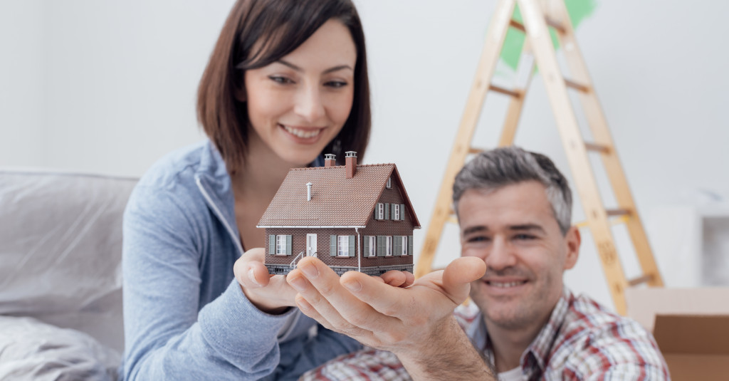 couple holding a model of their dream home