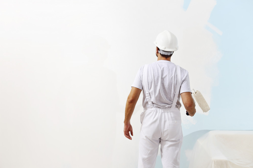 professional in uniform painting a wall