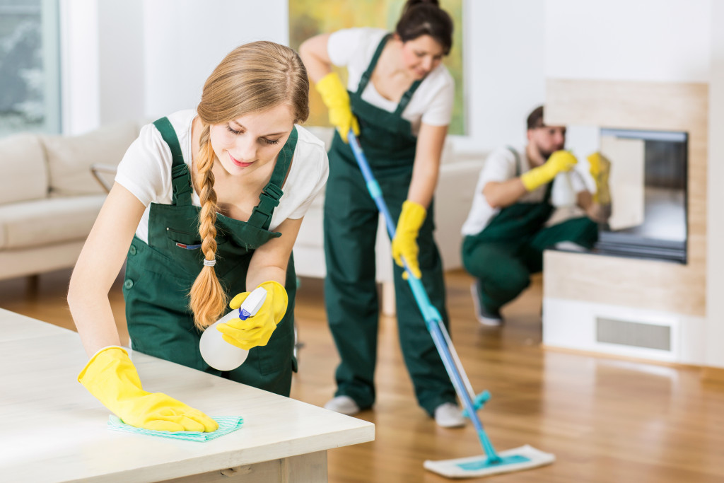 A group of professional cleaners cleaning a house