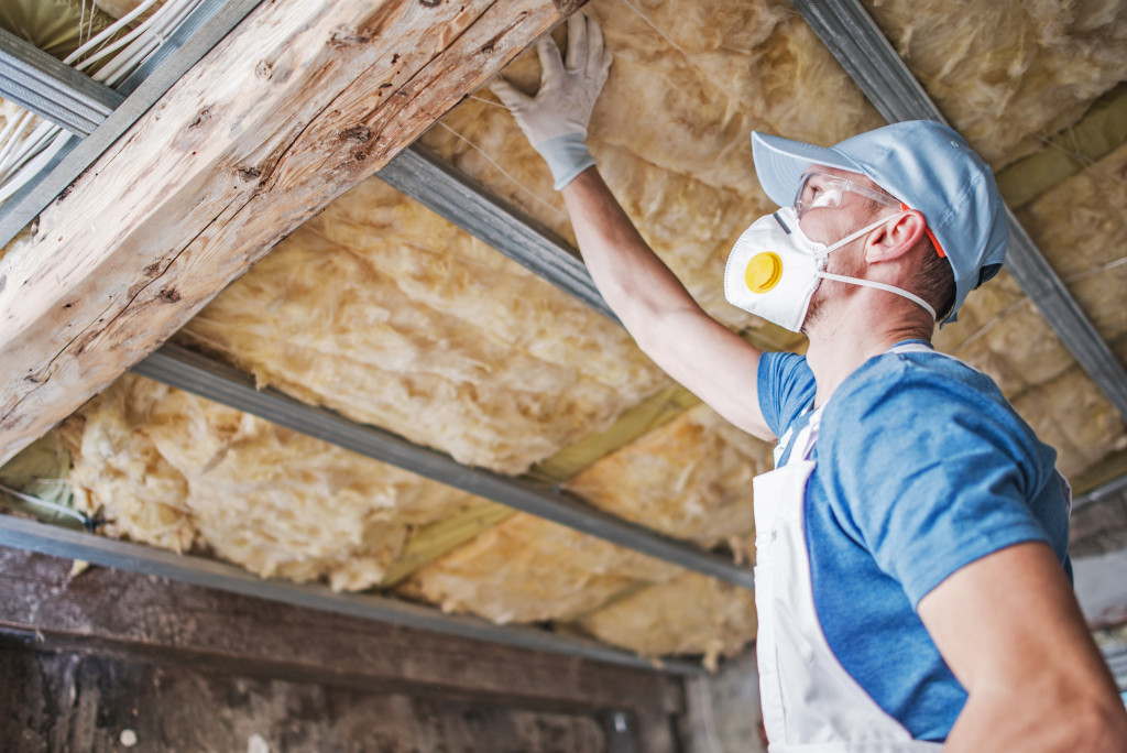 A man installing insulation on the roof