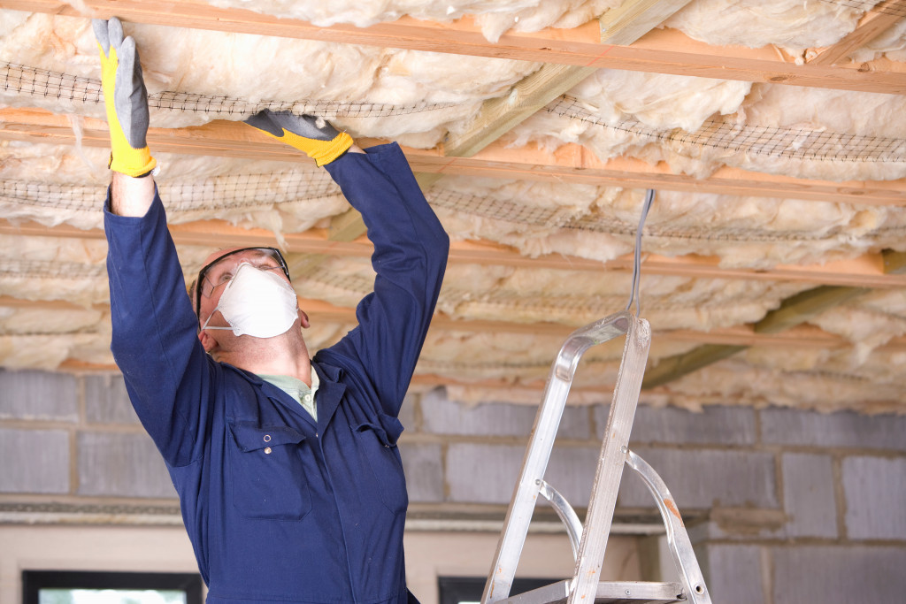 Worker installing the ceiling insulation of a house.