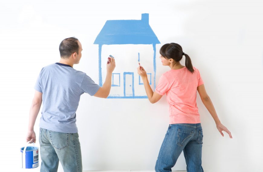 boy and girl using paintbrushes while renovating their home.